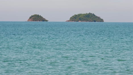 4k footage, telephoto shot of two tropical islands with turquoise waters in the gulf of thailand