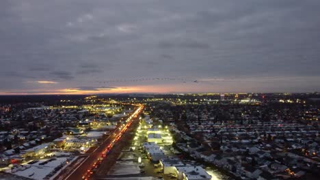 tomada de avión no tripulado del paisaje urbano con atasco de tráfico y pájaros volando al atardecer en candiac, quebec, canadá