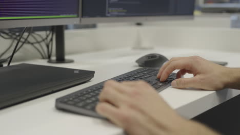 A-man-is-typing-on-a-computer-keyboard,-close-up,-side-view