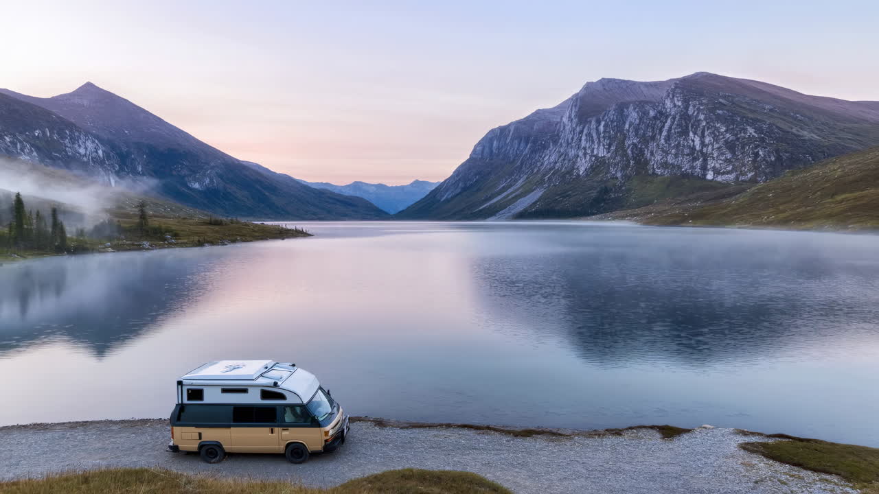 Camper vicino a un lago di montagna all'alba, cielo pastello riflesso nell'acqua a specchio, nebbia bassa che avvolge la riva, stile vintage.