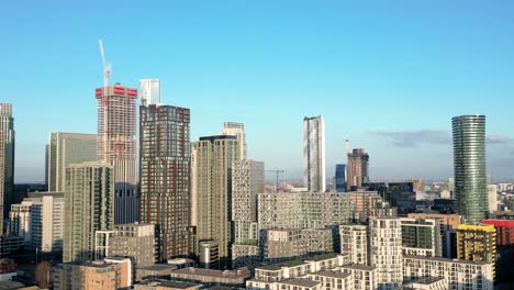 Isle-of-Dogs-skyline-in-London-CBD-against-blue-sky,-aerial-trucking