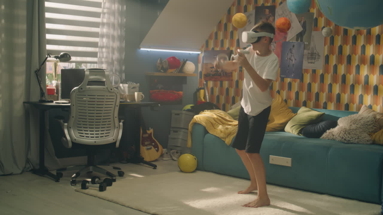 Young Boy with VR Headset and Joysticks Plays a Game and Making Punches Gestures