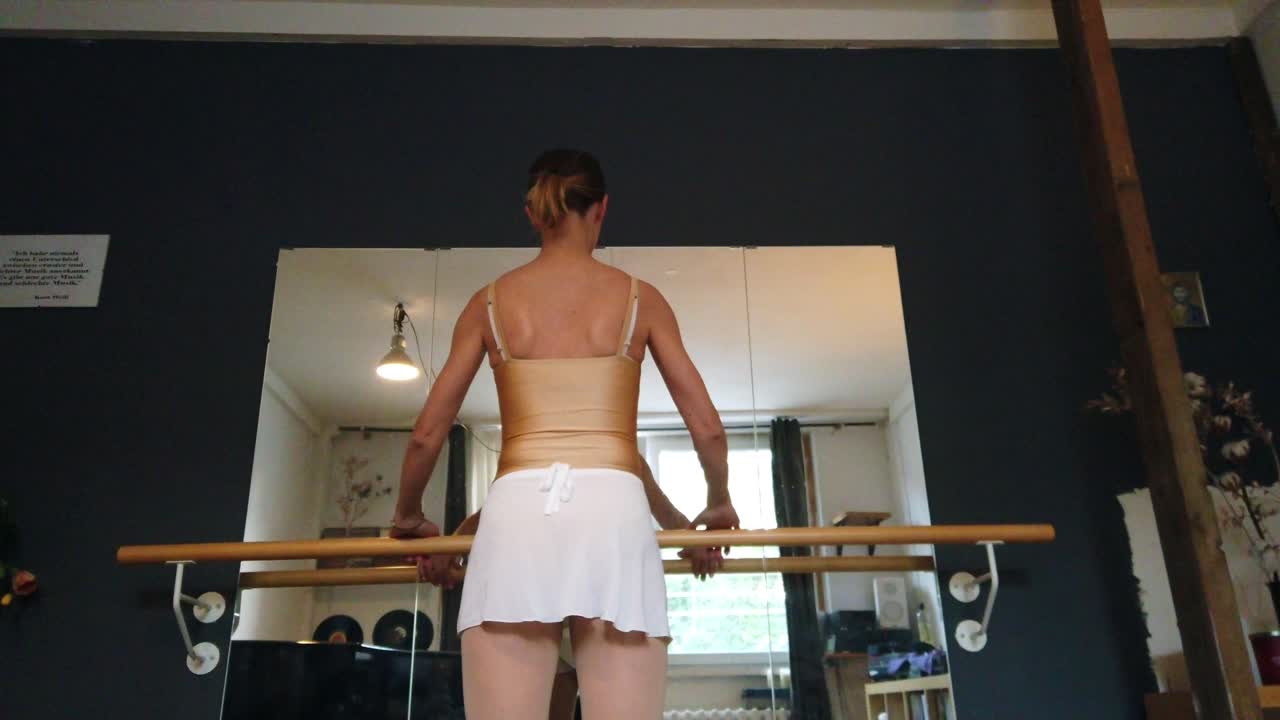 desde detrás del espejo retroceda increíble toma de una bailarina con falda blanca y cuerpo dorado en cámara lenta en el estudio de ballet urbano de berlín 4k cinematográfico por philipp marnitz