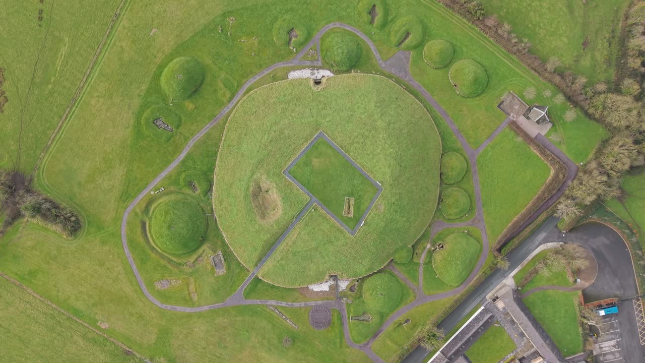 Ancient Knowth passage tomb, aerial view, lush green landscape, Irish heritage site