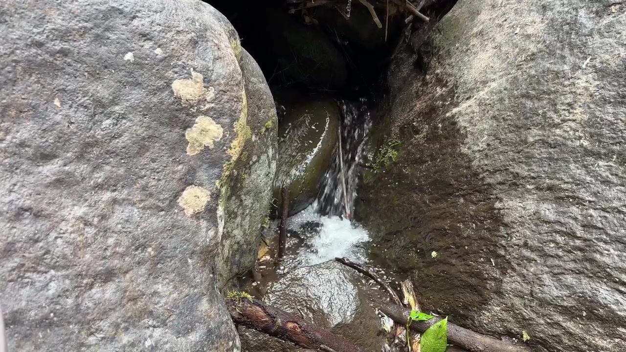 Pequeno Riacho Fluindo Entre Grandes Rochas Musgosas na Natureza