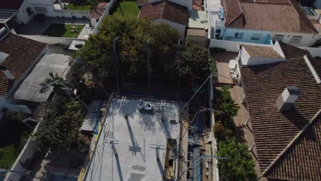 desde la ladera de la montaña, los techos de los edificios crean un mosaico contra el cielo, mientras que los árboles dispersos tejen su camino entre las estructuras