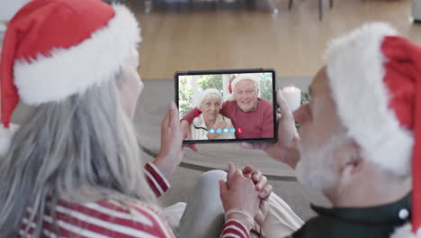 Dos-Felices-Parejas-Caucásicas-Mayores-Teniendo-Videollamadas-Con-Tabletas-Navideñas,-Cámara-Lenta