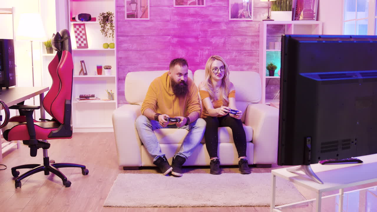 Couple Playing Video Games on Couch in Pink Room
