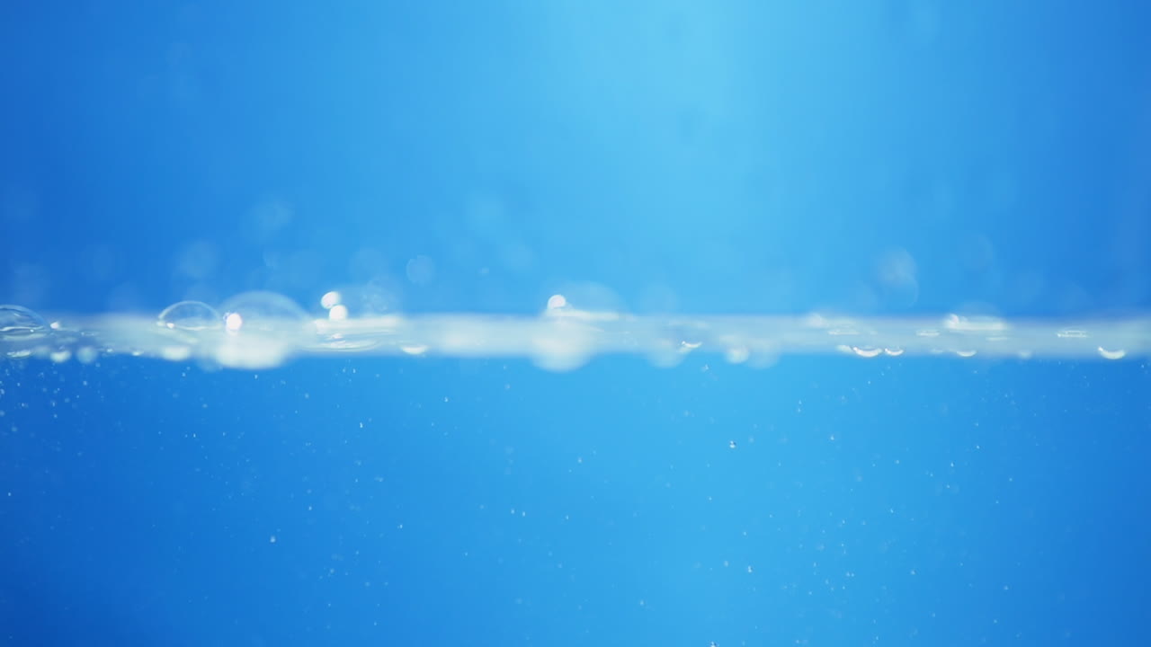 A crystal-clear drop of water drips gracefully in slow motion, capturing the essence of purity, health, and clean living.