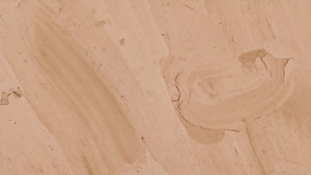Panning camera revealing circular chip on beige painted plaster in room, tracking hairline cracks