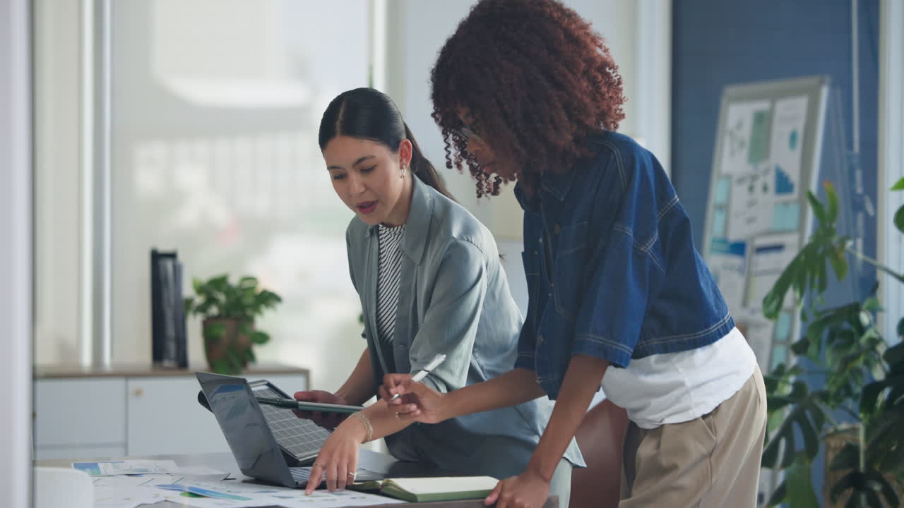 Diverse Businesswomen Collaborating on Laptop and Tablet in Office
