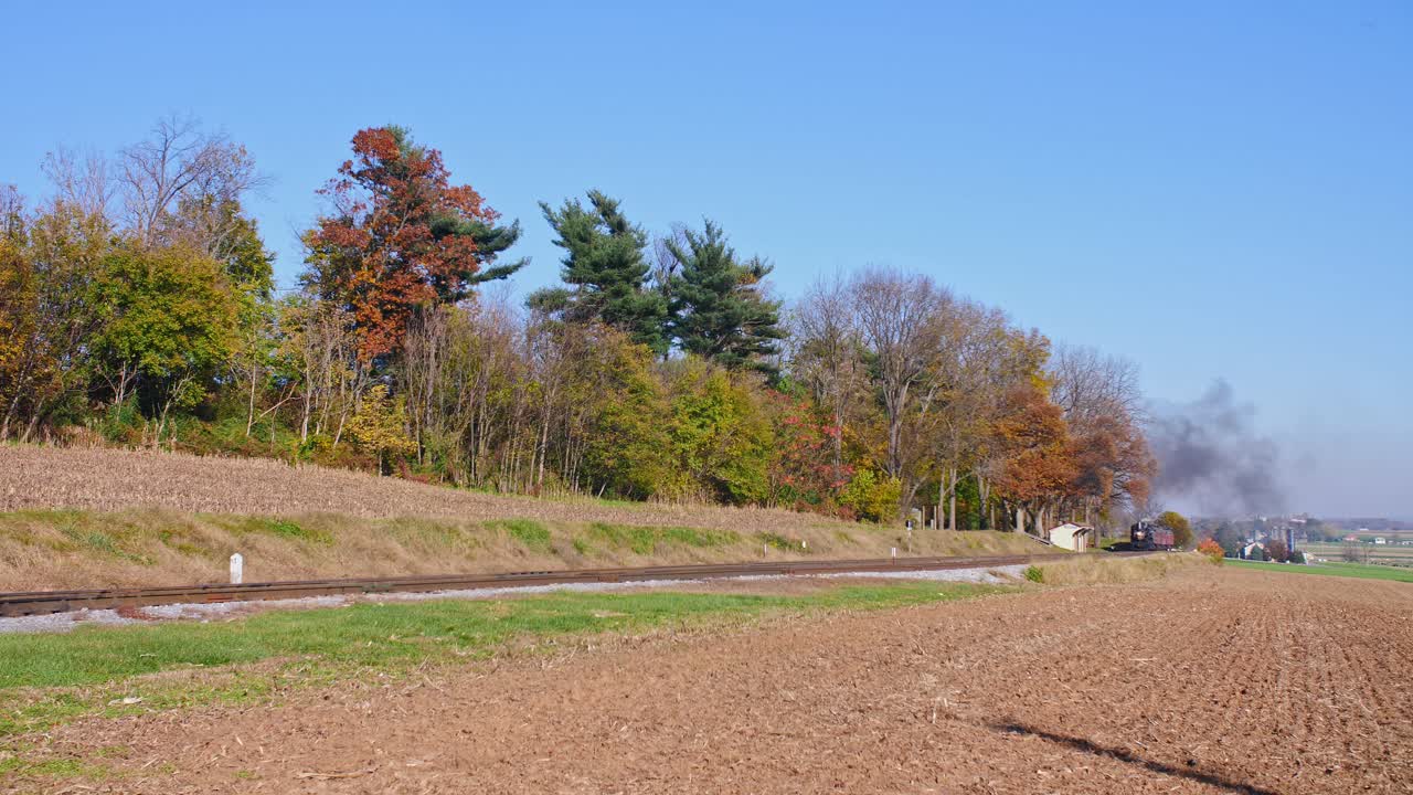 화창한 가을날 연기와 증기로 접근하는 골동품 복원 증기 기관차