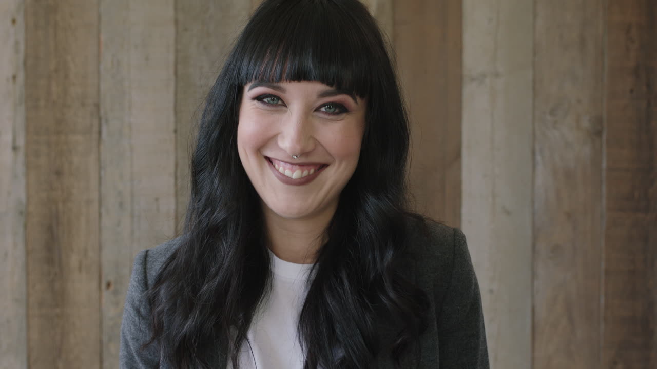 retrato en primer plano de una joven feliz mujer caucásica mirando a la cámara riendo alegre atractiva elegante mujer de pelo largo negro