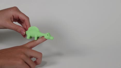 stretching and flinging a green dinosaur toy