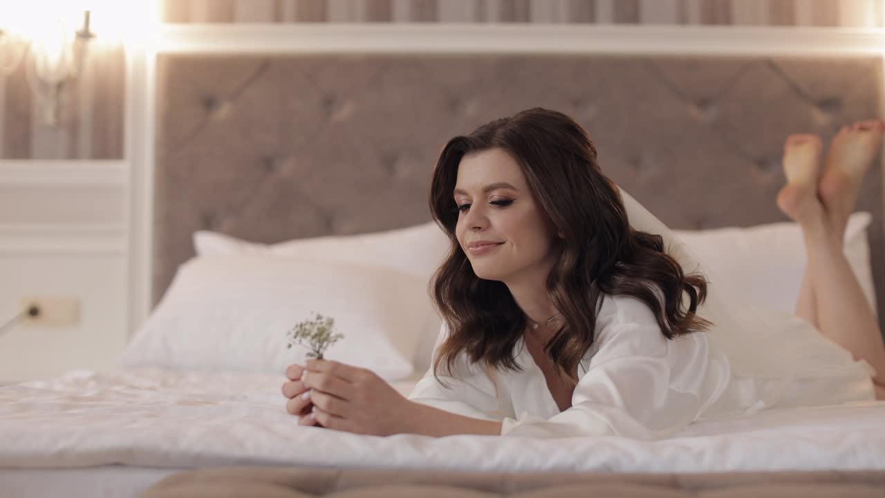 침대에 휴식을 취하는  옷을 입은 아름다운 신부