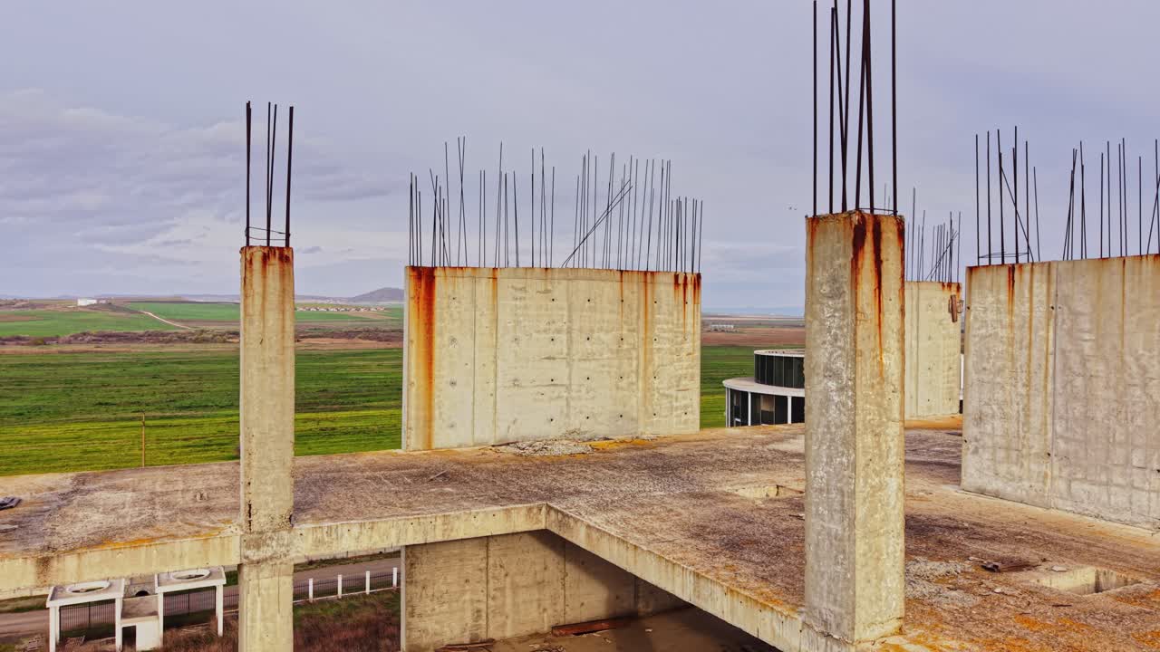 Construction site overlooking a green landscape with concrete pillars