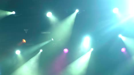 equipamiento de iluminación portátil 4k uhd en el escenario del concierto durante la actuación. los rayos de luz del foco a través del humo. rayos azules y amarillos púrpuras verdes de luz