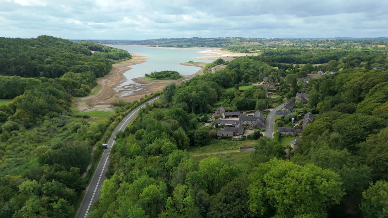 Drone shot of Carsington Water reservoir with low water level and countryside traffic in Derbyshire Dales United Kingdom