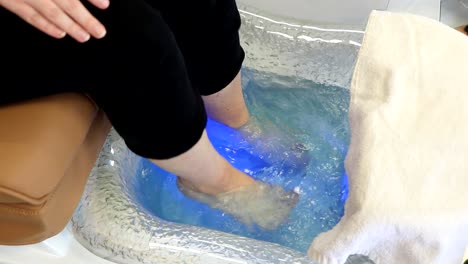 a girl has feet bath massage in a beauty salon