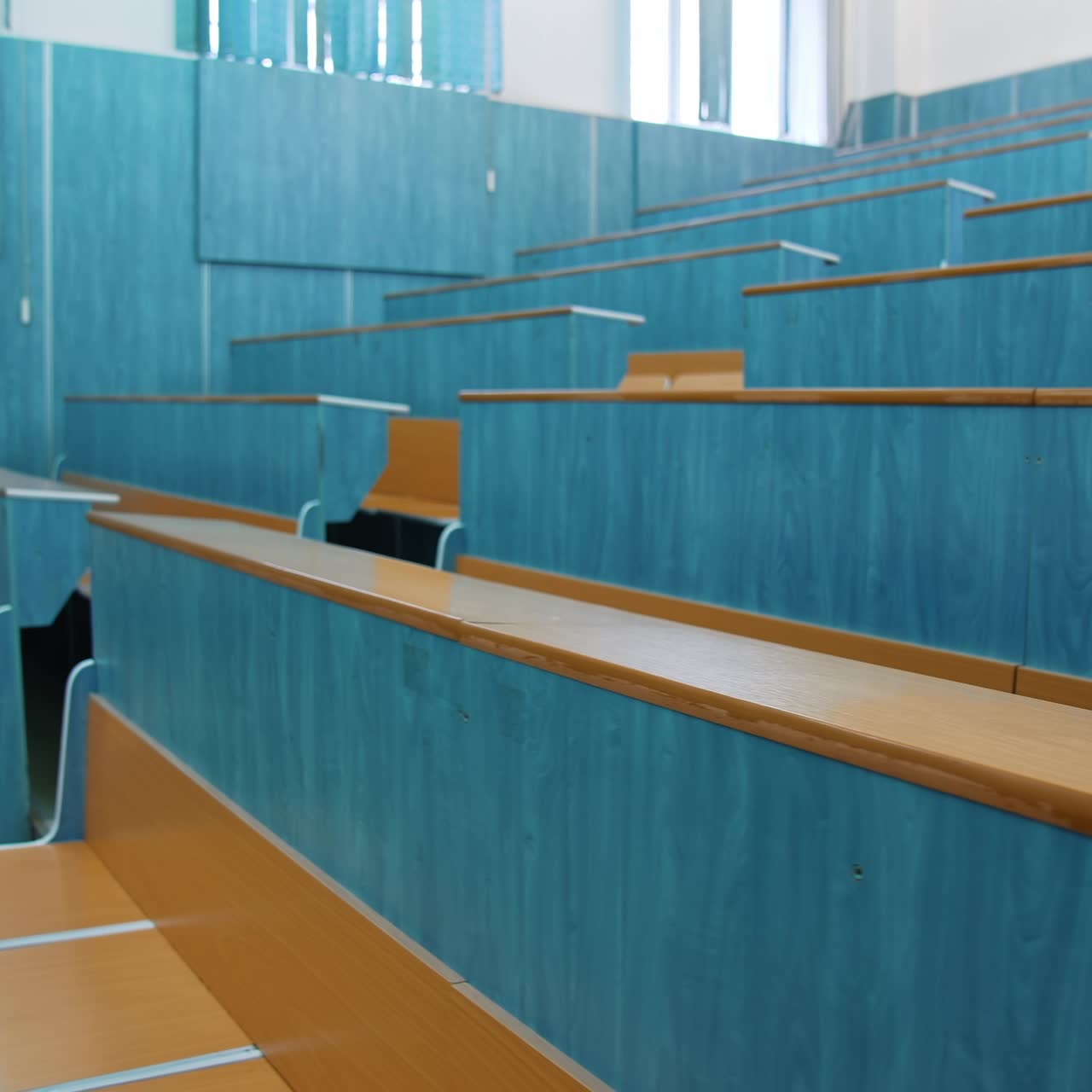 Empty lecture hall. Auditorium with wooden desks and chairs at educational center. Conference hall without students in the university