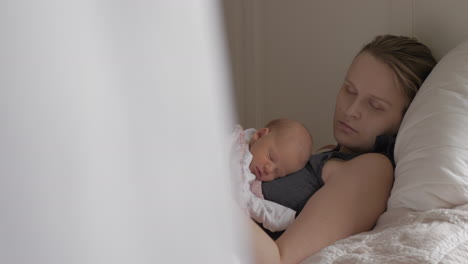 Young-mother-sleeping-with-newborn-daughter