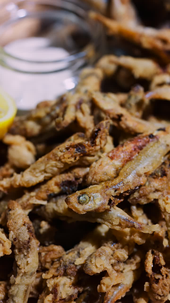 Close up of a Fritto Misto dish with salmon and potatoes at a restaurant. Vertical