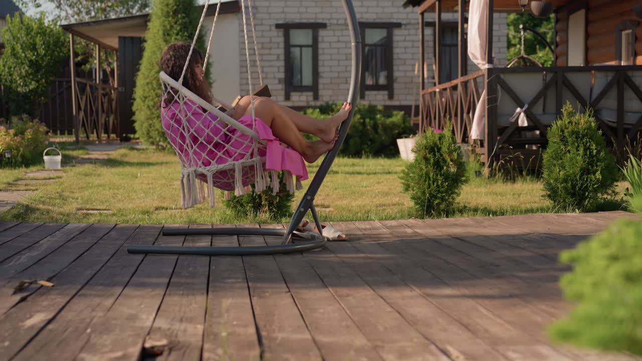 Gentle Woman Sits And Reads On Sunny Patio, Woman Peacefully Explores Stories While Sitting On Cozy Wooden Deck, Woman Finds Tranquility By Reading Book On Warm Summer Afternoon Outside