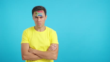 dignified and serious man with south african flag painted on face