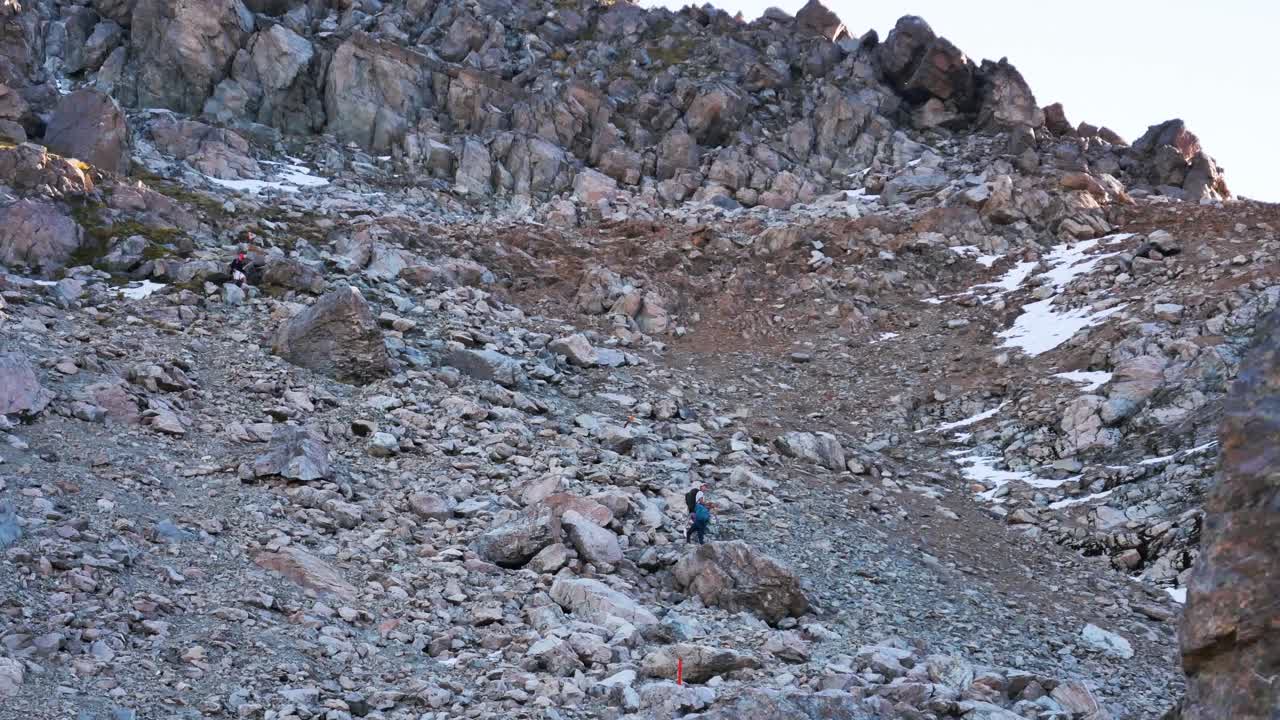 hiker navigates boulder field on mountainside