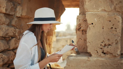 woman restoring ancient stone wall