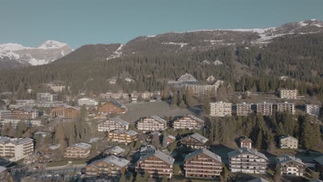 Rotating-aerial-over-alpine-houses-of-beautiful-rich-mountain-resort-Crans-Montana,-Switzerland