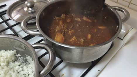mexican stew, beef fillets in morita chile sauce and potatoes. spicy recipe. boiling on the stove
