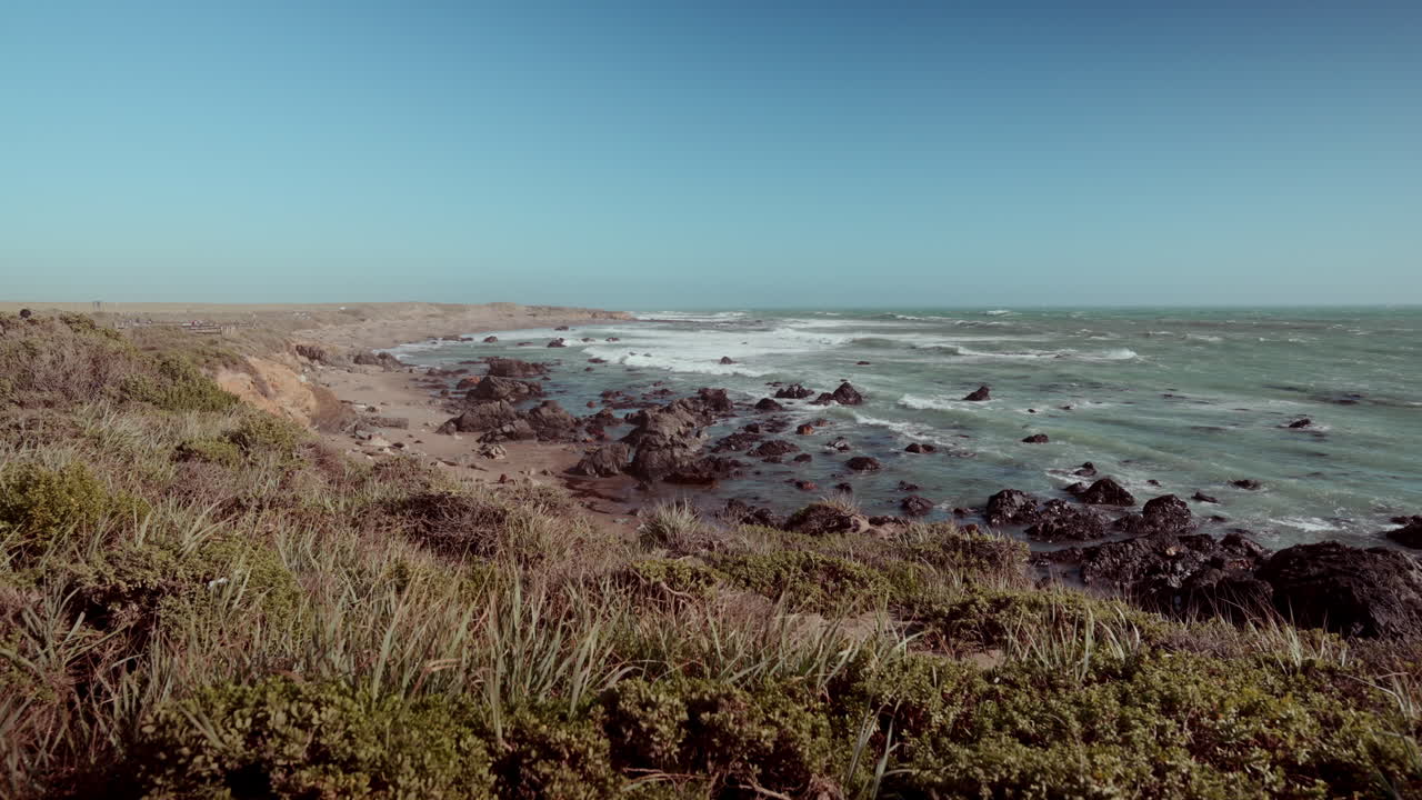 Paisagem de Praia Costeira com Ondas e Rochas