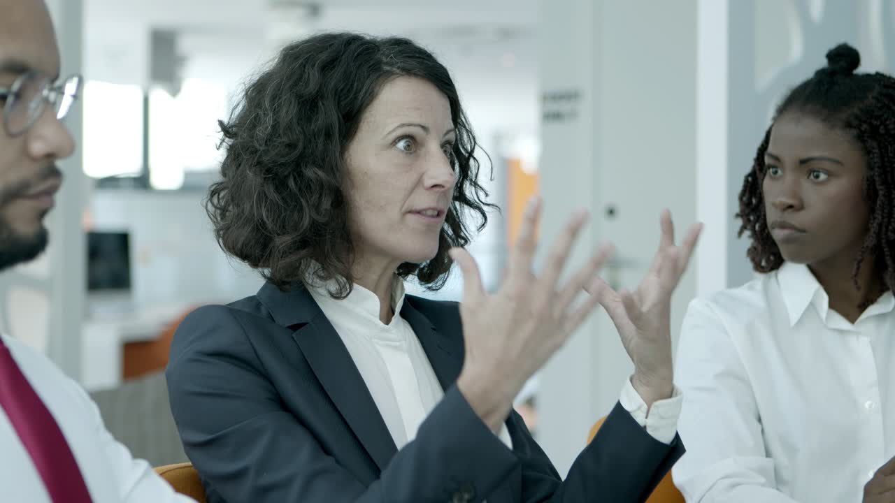 mujer de negocios de mediana edad hablando con colegas