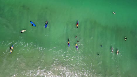 People-on-surfboards-at-waters-of-Lombok's-Selong-Belanak-Beach,-a-tropical-haven-on-the-Indonesian-island