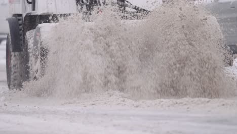 snow brush sweeper tractor clearing snow from road after snow storm, slow motion