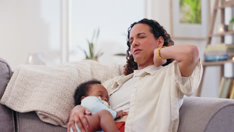 madre cansada sosteniendo al bebé en el sofá