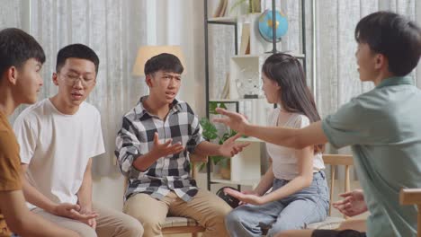 asian teen group sitting in chairs forming a circle arguing and trying to blame each other