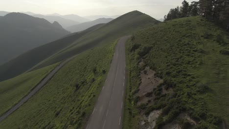 unrecognizable person on electric scooter along mountain road, iraty on atlantic pyrenees, france
