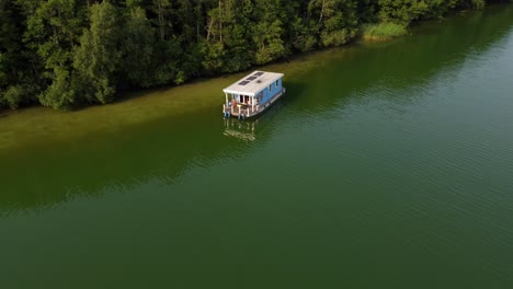 several motor boats driving on a green natural lake next to a forest in brandenburg, germany