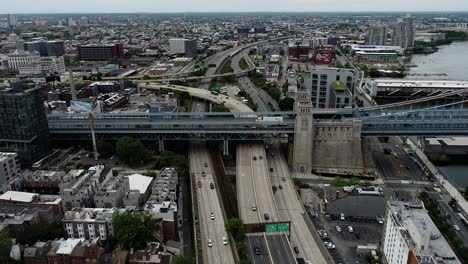 aerial footage panning outward revealing an interchange between the benjamin franklin bridge connecting to the highways in center city philadelphia