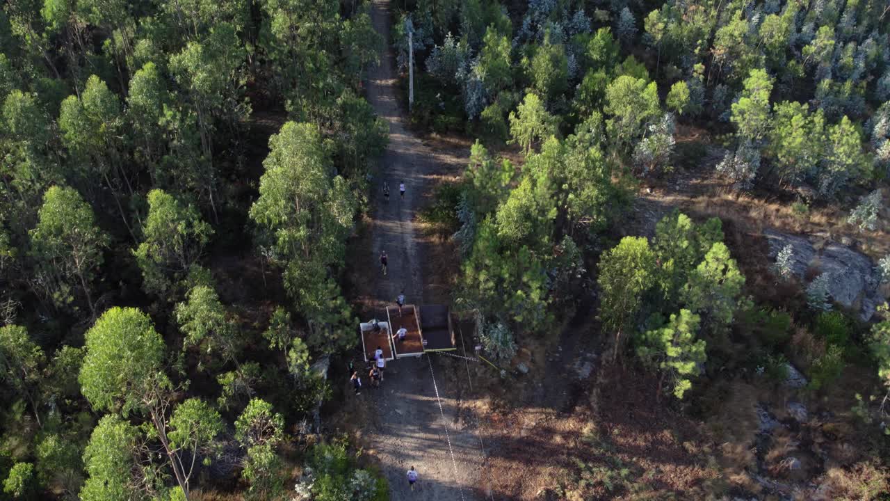 Runners make their way through a dense forest trail at Monte Franqueira, Barcelos
