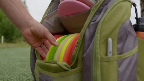 sacando un disco de golf de la bolsa - primer plano
