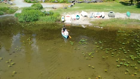 dos hombres en canoa en un lago remando hasta la orilla