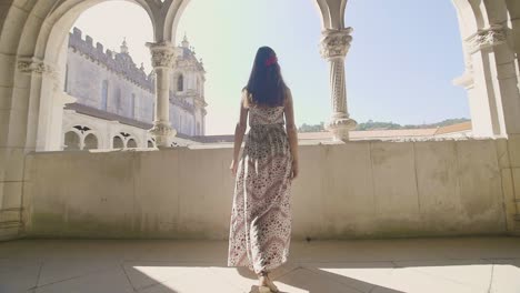 woman in a dress looking at a monastery