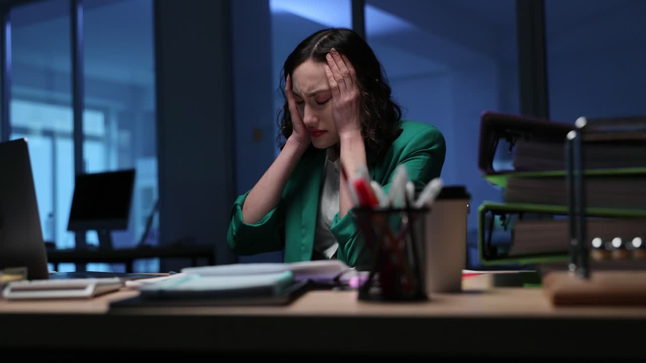 Stressed woman working late at the office