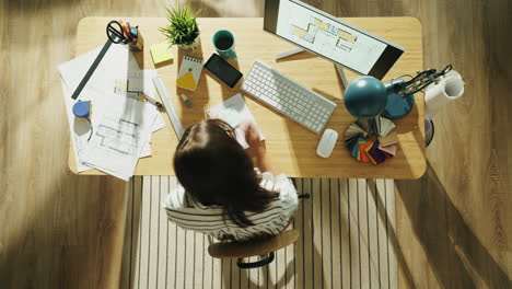 architect working on floor plans at her desk