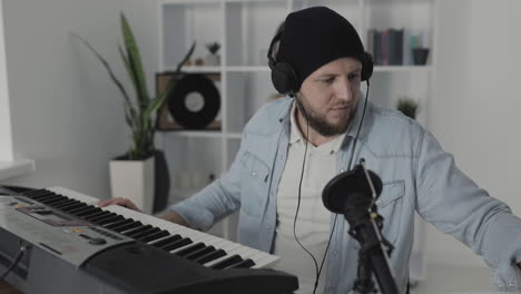 youn man musician singing and playing electric keyboard at home