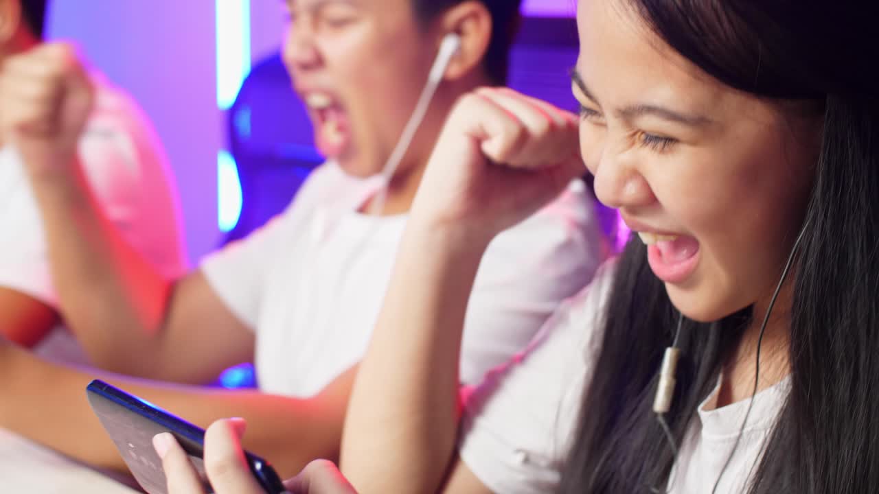 Close Up Team Of Asian Esport Gamers Playing In Competitive Video Games On A Cyber Games Tournament By Mobile Phone And Celebrate Win