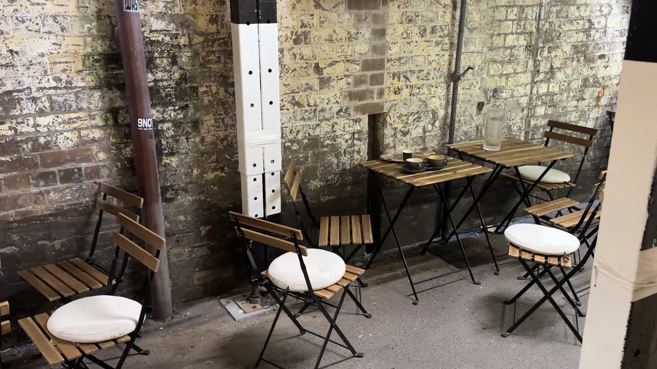 Laneway empty cafe Sydney NSW Australia rustic alfresco tables along alley wall